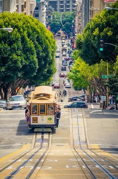 a trolley car is going down the street in front of some buildings and cars on it