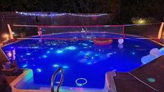 the pool is lit up with colorful lights and decorations for an outdoor party or event