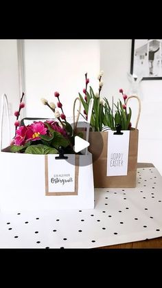 two bags filled with flowers sitting on top of a white table covered in polka dots