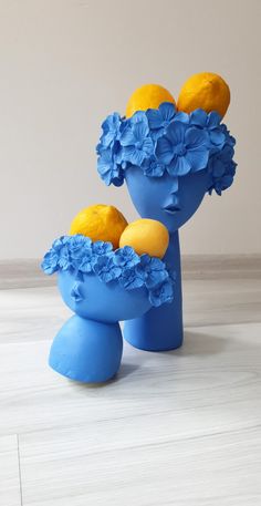 two blue vases with lemons and flowers in them