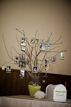 a vase filled with branches and pictures on top of a table