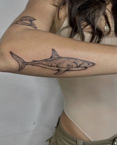 a woman with a shark tattoo on her arm