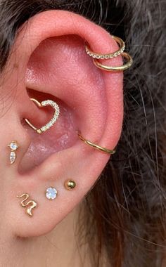 an ear with three different types of piercings