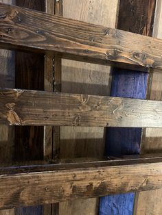 an old wooden shelf with blue cloths on it's sides and wood planks in the background