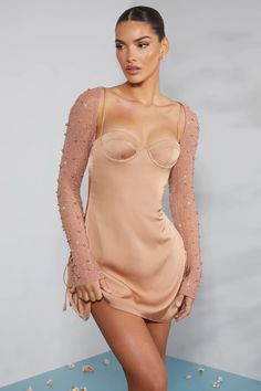 a woman in a nude dress posing for the camera