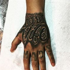 a person's hand with tattoos on it and the words made in black ink