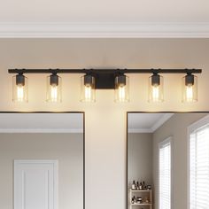 a bathroom vanity light with three lights on the top and one in the middle, hanging over a sink