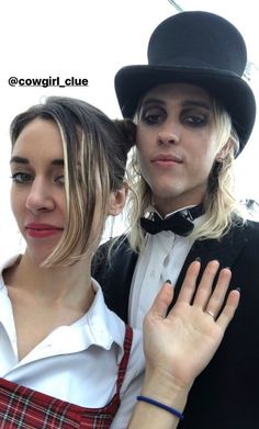 two people wearing hats and ties posing for a photo with one woman's hand on her shoulder