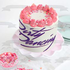 a white cake with pink frosting and sprinkles