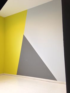 an empty room with yellow, grey and white walls