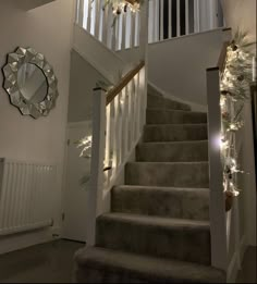 the stairs are decorated with christmas lights and garlands on them, along with a mirror