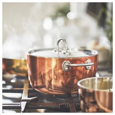 a copper colored pot and pan sitting on top of a stove