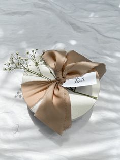 a bouquet of baby's breath tied to a white box with a name tag