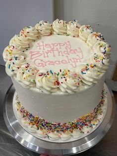 a birthday cake with white frosting and sprinkles