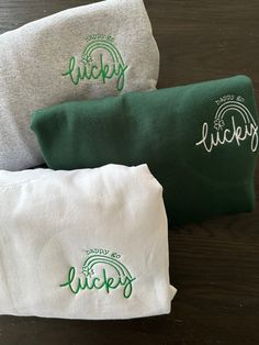 three green and white pouch bags sitting on top of a wooden table next to each other