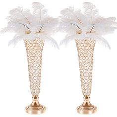 two gold vases with white feathers in them on a white background, one has a golden base