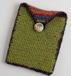 a crocheted green shirt with a button on it