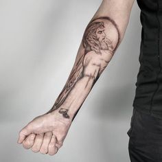 a man's arm with a jesus tattoo on it