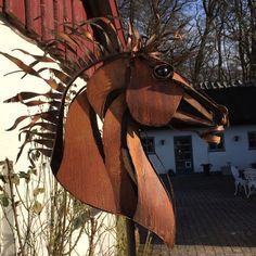 a metal horse head hanging from the side of a building