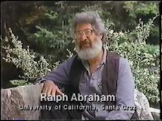 an old man with a beard and glasses sitting on a rock in front of trees