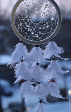 a white dream catcher hanging from a window