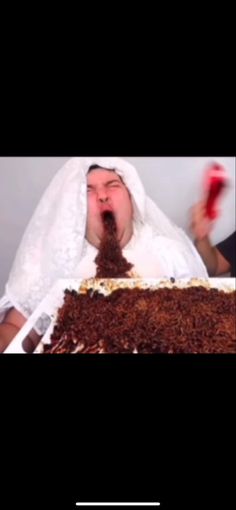 a man in a wedding dress blowing out the candles on his cake