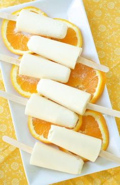 homemade orange creamsices recipe on a plate with popsicles cut in half and stacked on top