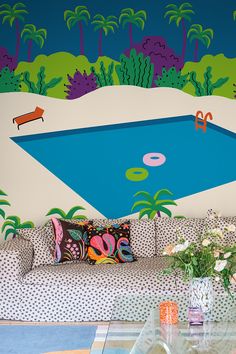 a living room filled with furniture and a pool painted on the wall next to it