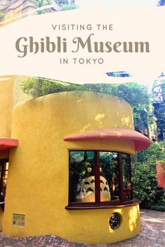 a yellow building with a sign that says visiting the ghibi museum in tokyo