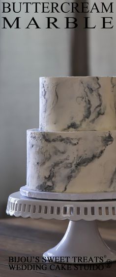 a three layer marble cake sitting on top of a white plate with the words buttercream marble above it