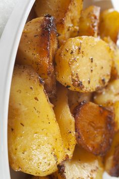 cooked potatoes with seasoning in a white bowl