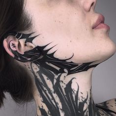 a woman with black and white tattoos on her neck