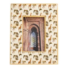 an ornate photo frame with giraffes and palm trees on the outside wall