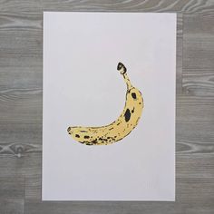 a banana drawn with black spots on white paper