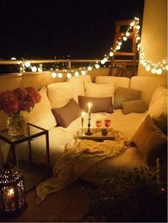 a couch sitting on top of a wooden floor next to a table filled with candles