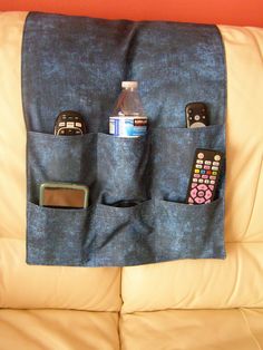 a couch with a cell phone and remote control in the pocket on top of it