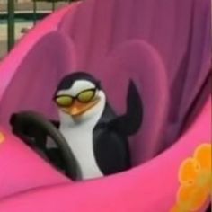 a penguin driving a pink car with sunglasses on