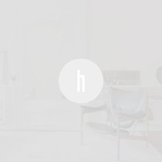 a white room with chairs and a round sign on the wall that says h in front of it