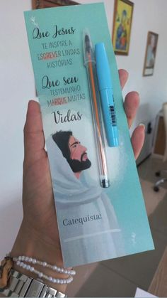 a person holding up a card with a pen in it and an ad for jesus