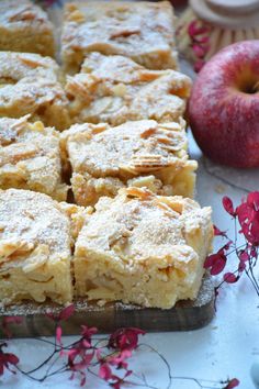 several pieces of cake sitting on top of a wooden cutting board next to an apple