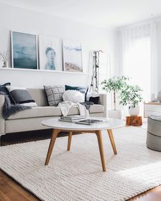 a living room filled with furniture and pictures on the wall above it's coffee table