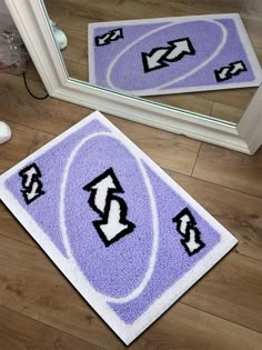 two bathroom rugs on the floor in front of a mirror