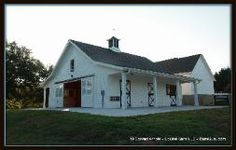 a large white barn with a red door