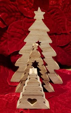 a small wooden christmas tree sitting on top of a red blanket