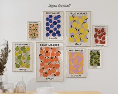 an assortment of fruit market posters hanging on the wall above a dining room table with utensils