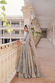 a woman in a wedding dress standing on a balcony