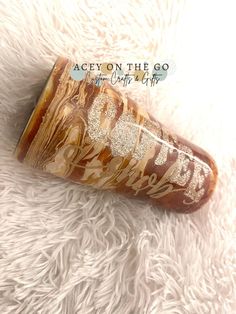 a brown and gold tube sitting on top of a white rug with writing on it