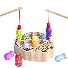 a wooden toy with different colored fish on it's body and two pegs in the middle