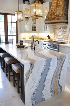 a kitchen with marble counter tops and an island in front of the stove top oven