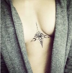 a woman's chest with a small tattoo on her left side, and an arrow in the middle